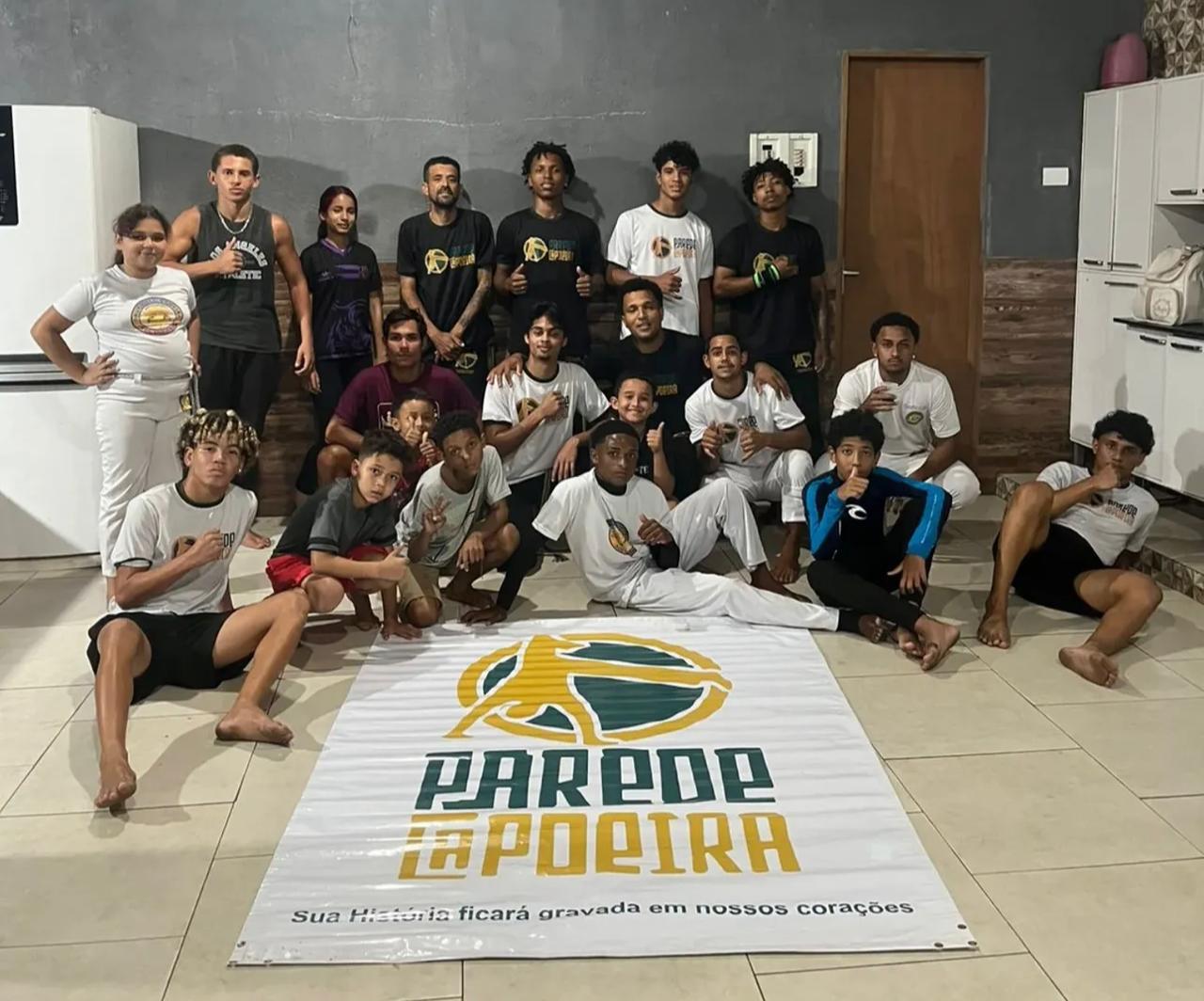 Alunos do Parede Capoeira reunidos ao lado da lona do grupo
