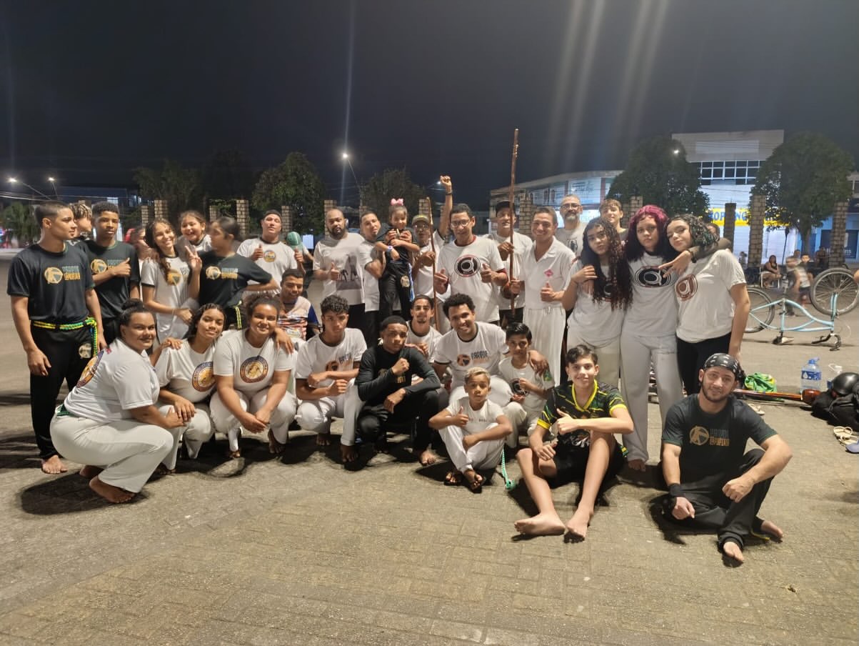 Grupo Parede Capoeira reunido após roda de capoeira em praça à noite